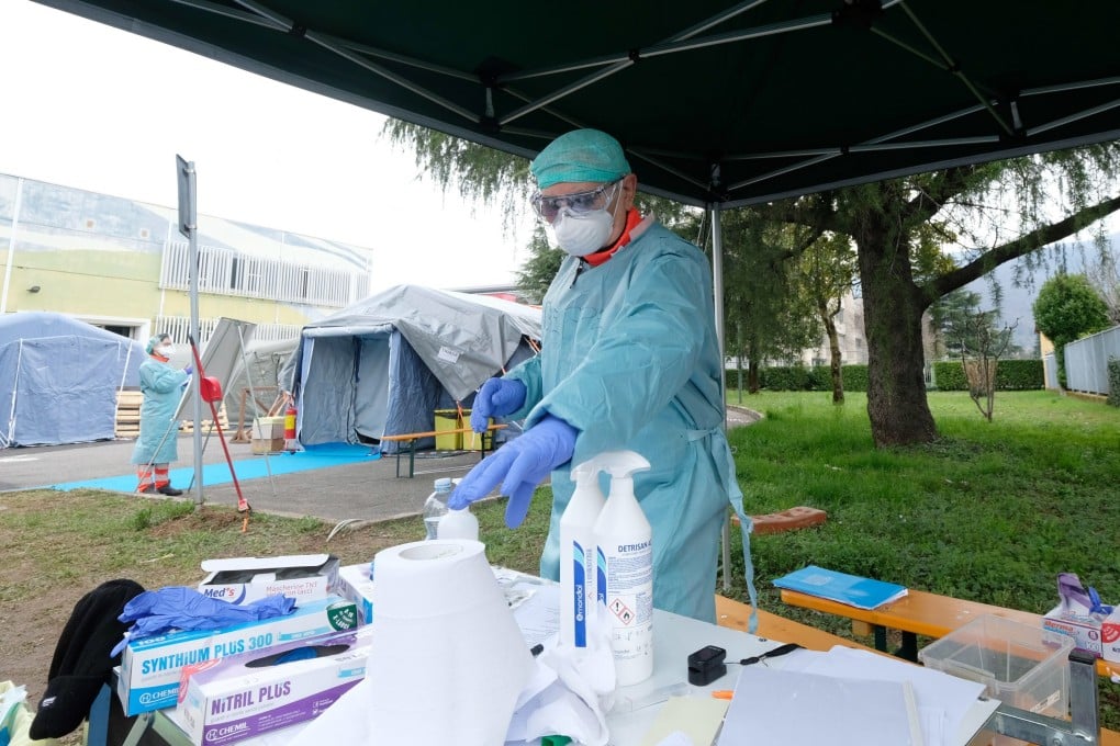 A health worker wearing a protective suit and face mask works near one of the tents set up outside the hospital in Brescia, Italy on Monday. Photo: EPA-EFE