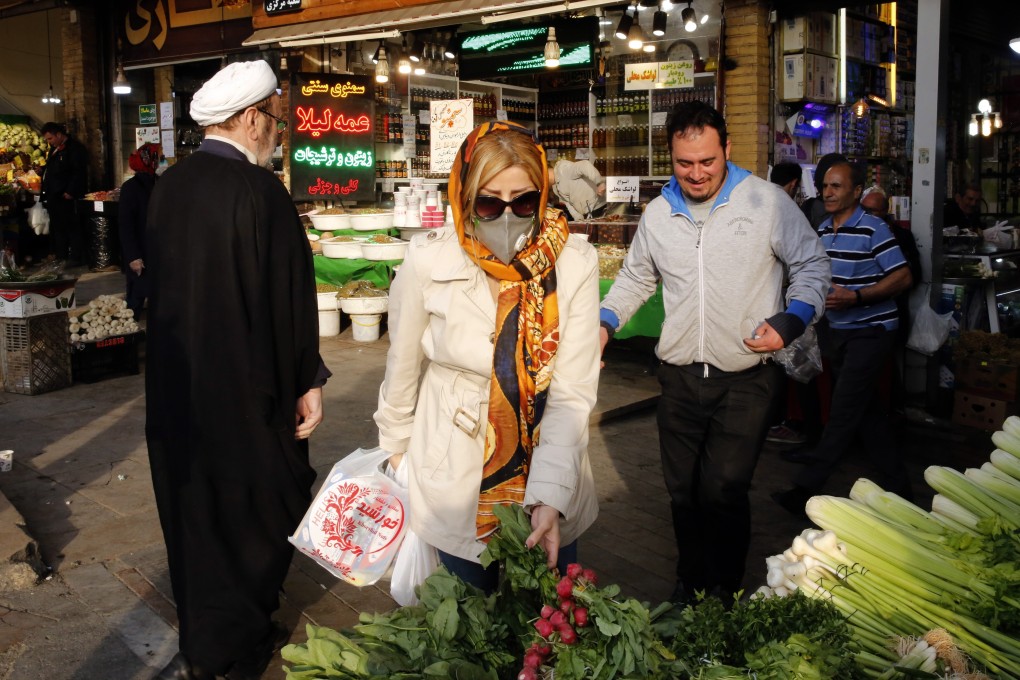 An Iranian woman wearing a face mask buys fruits in a market in Tehran. Photo: EPA-EFE