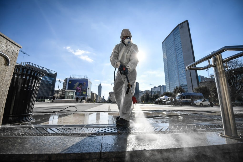 A worker disinfects the square of the Stazione Centrale railway station in Milan, Italy. Photo: DPA