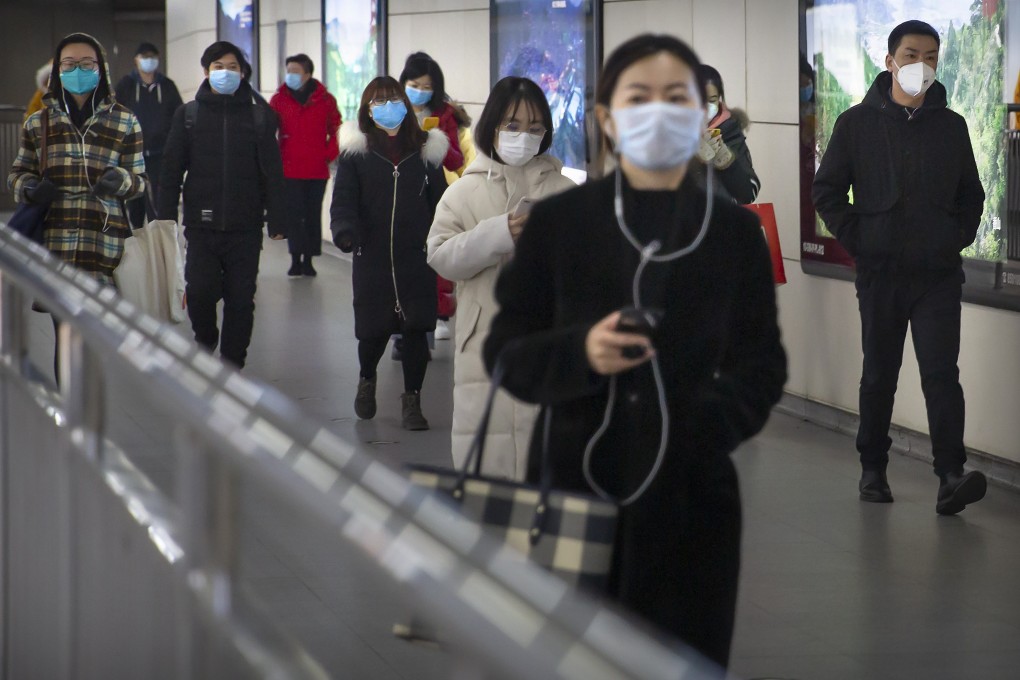 People wearing face masks walk through a subway station in Beijing. Photo: AP