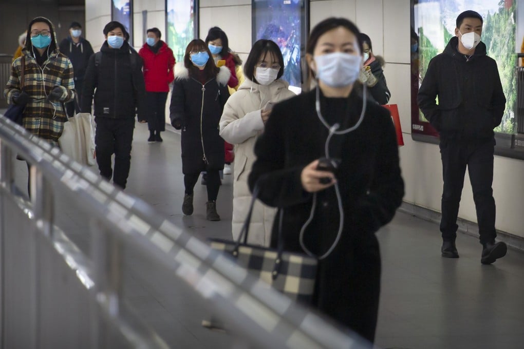 People wearing face masks walk through a subway station in Beijing. Photo: AP