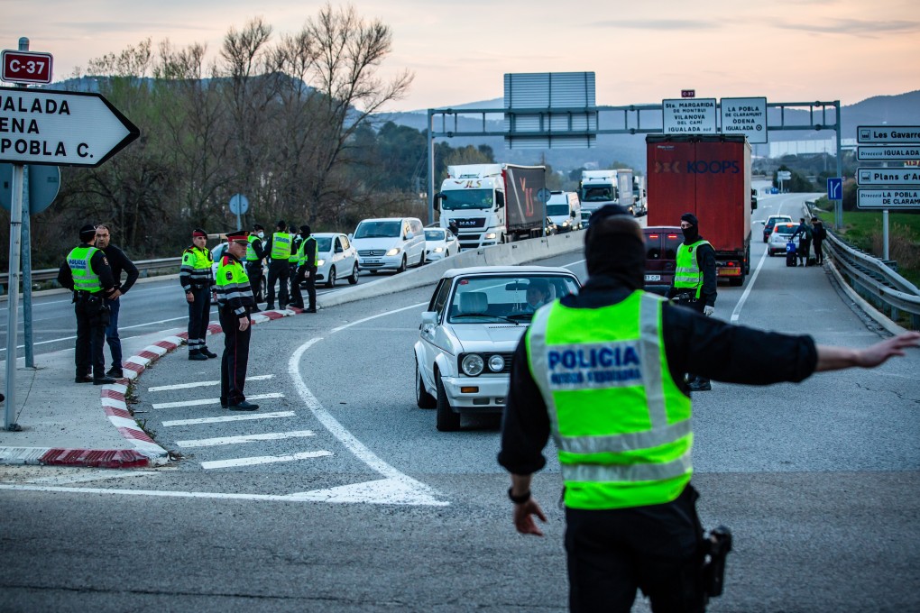 Members of the Mossos d'Esquadra police force direct drivers. Photo: Bloomberg
