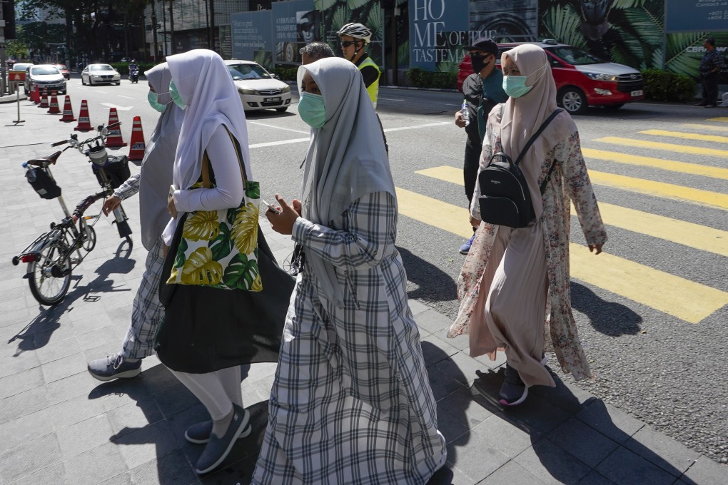 Pedestrians wearing face masks in a Kuala Lumpur shopping district on March 15. Photo: AP