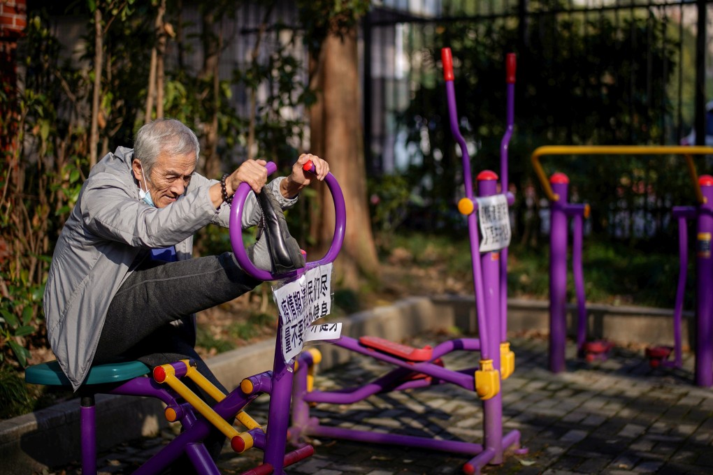 An elderly man stretches on a machine, with a sign advising residents to avoid exercising outdoors during the coronavirus outbreak, at a park in Shanghai on March 12. Photo: Reuters