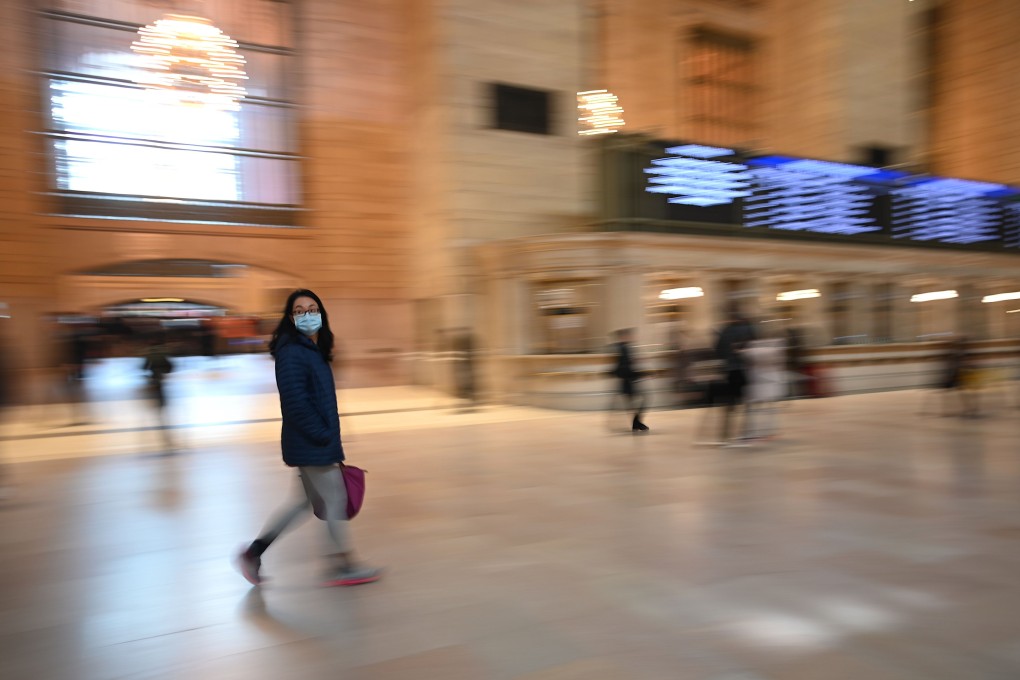 A lone woman wears a mask as she walks in an almost empty Grand Central Terminal in New York on Monday, as the city began its latest set of restrictions to combat the coronavirus outbreak. Photo: AFP