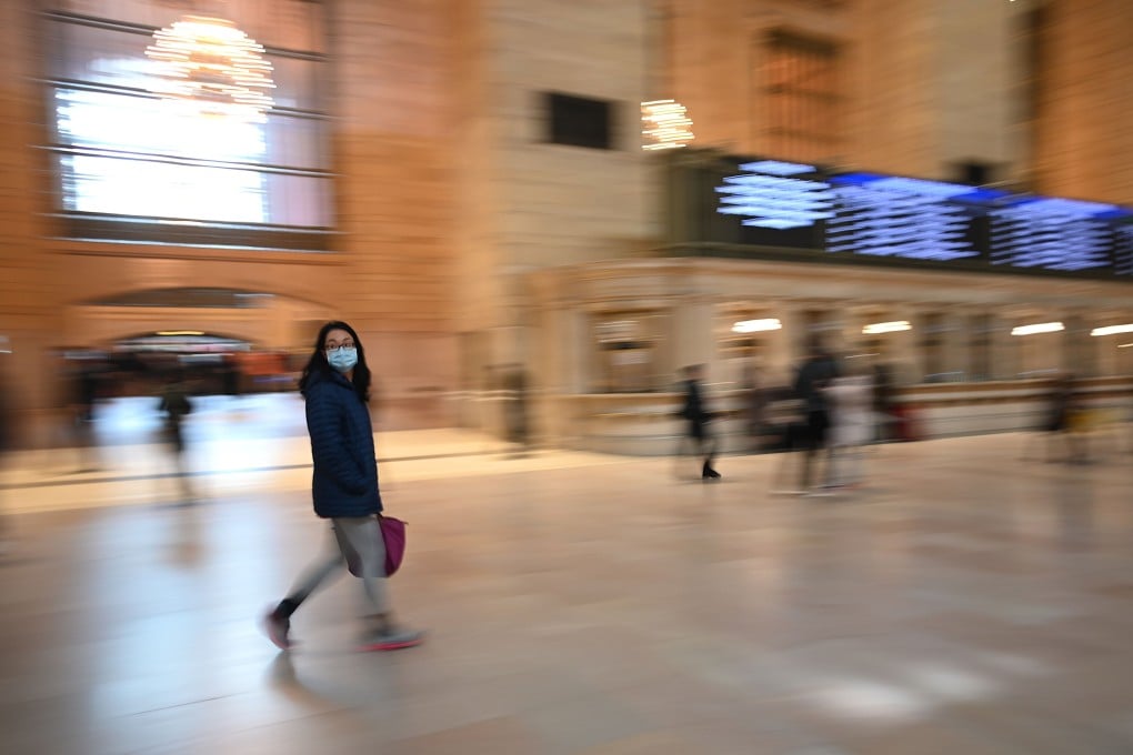 A lone woman wears a mask as she walks in an almost empty Grand Central Terminal in New York on Monday, as the city began its latest set of restrictions to combat the coronavirus outbreak. Photo: AFP