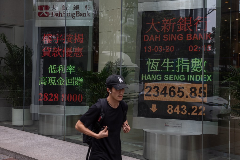 Man walks past an electronic billboard showing the Hang Seng Index in Hong Kong, on March 2020. Photo: EPA-EFE