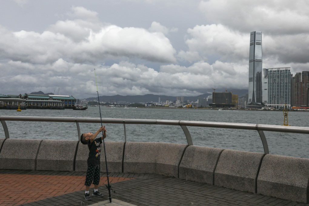 A child with a fishing rod at the Central harbourfront on September 1, 2019. Steel handrails are ubiquitous along Hong Kong harbourfront promenades. Photo: Nora Tam