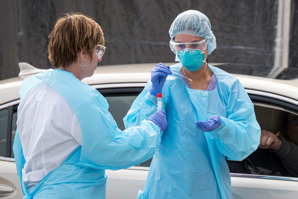 Medical personnel collect a sample from a patient at a drive-through Covid-19 testing clinic in San Francisco, California. Photo: Bloomberg