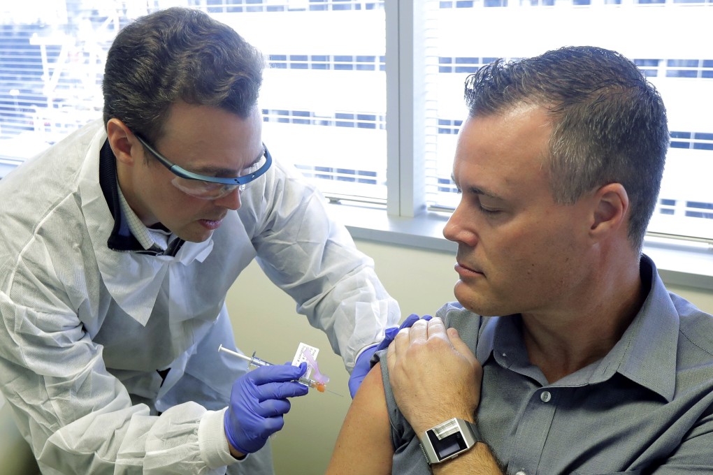 Pharmacist Michael Witte gives Neal Browning a shot in the first-stage study of a potential coronavirus vaccine on Monday in Seattle. Browning is the second patient to receive the shot in the study. Photo: AP