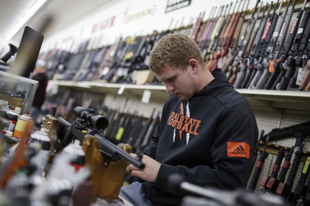 A man mounts a scope to a rifle at Ross Coin and Gun in Idaho on Monday. Photo: The Idaho Post-Register via AP