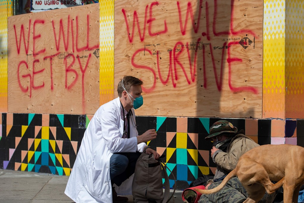 Stuart Malcolm, a doctor in San Francisco speaks with homeless people about Covid-19 on March 17. Photo: AFP