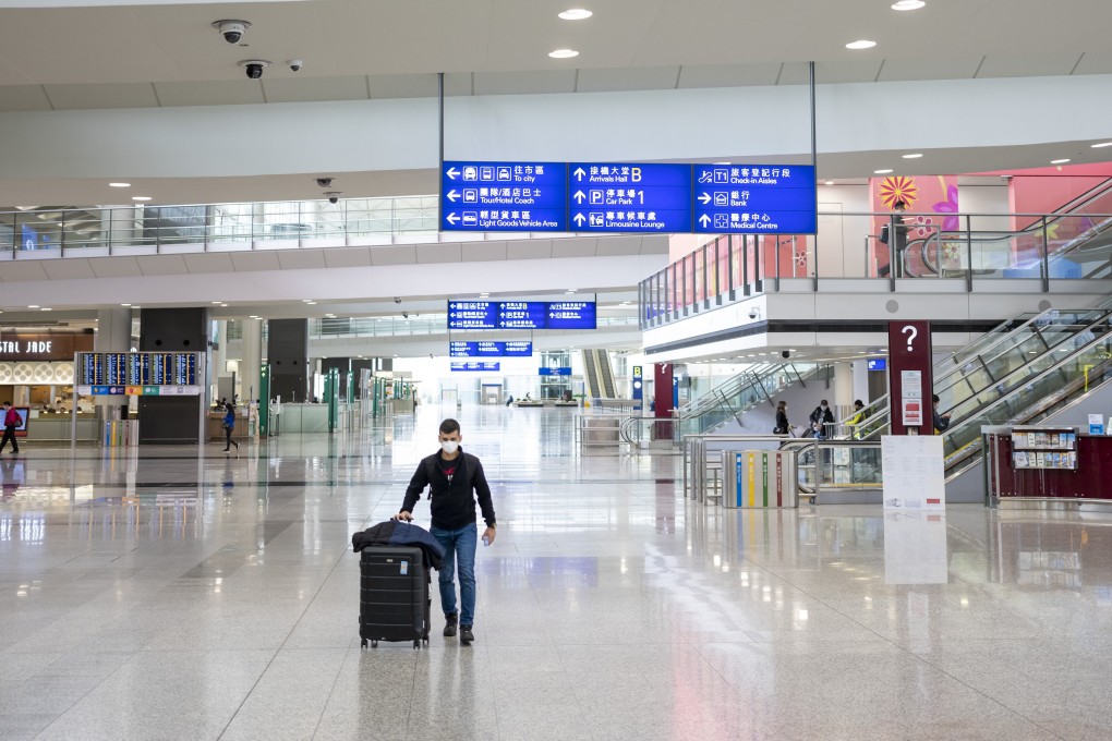 A traveller wearing a protective mask walks through the arrivals hall at Hong Kong International Airport on March 5. Photo: Bloomberg