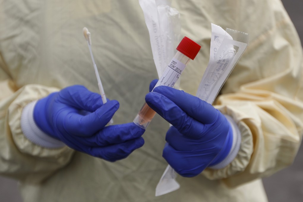 A nurse holds a Covid-19 testing kit at a drive-through station at a hospital in Royal Oak, Michigan. Photo: AP