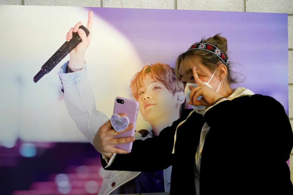 A BTS fan takes a selfie at a cafe decorated with photos and merchandise of the band in Seoul. Photo: Reuters