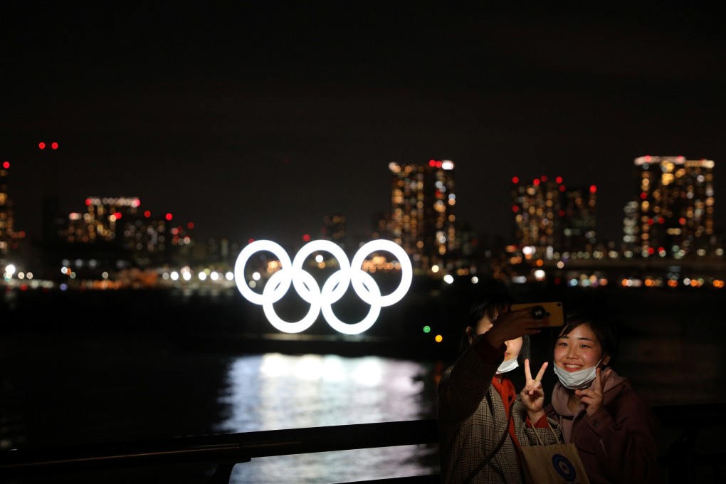 People take selfies in front of the giant Olympic rings at the waterfront area at Odaiba Marine Park in Tokyo. Photo: Reuters
