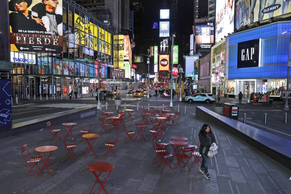 A woman walks through a lightly trafficked Times Square in New York, Monday, March 16, 2020. Bars and restaurants will become takeaway-only and businesses from cinemas and casinos to gyms and beyond will be closed. Photo: AP