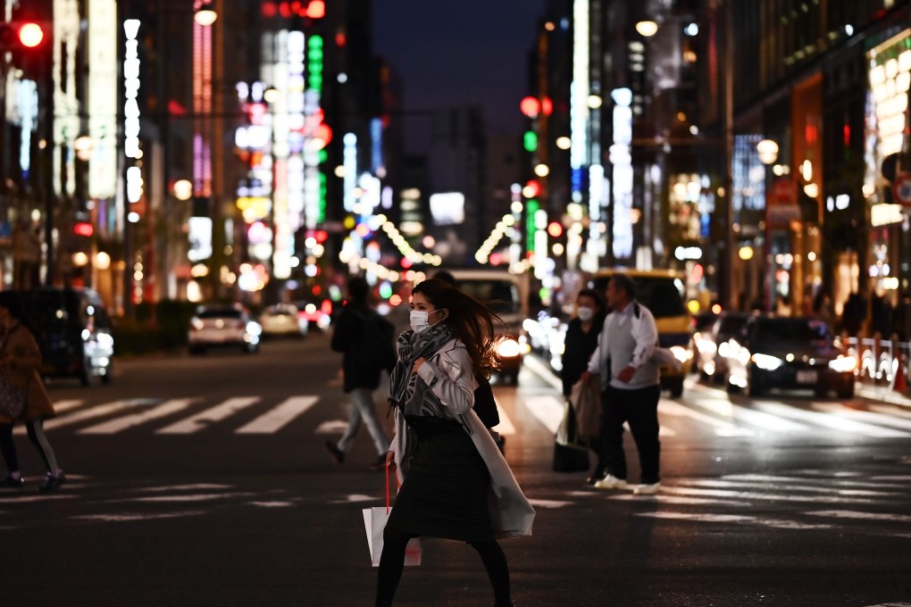 People wearing face masks cross a street in Tokyo’s Ginza area. Photo: AFP