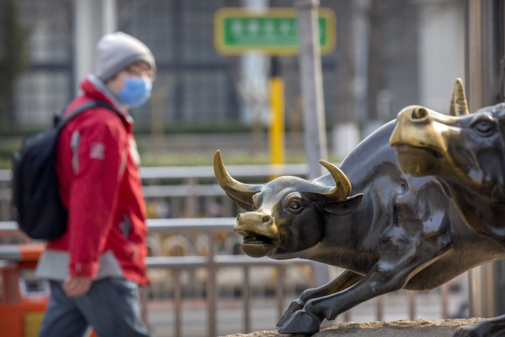 A man wearing a face mask walks past statues of bulls in Beijing, on February 28. Stock markets have continued to fall on spreading virus fears, deepening the global rout. Photo: AP