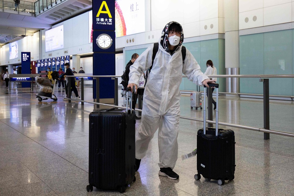 A passenger wearing protective gear as a precautionary measure against Covid-19, walks in the arrivals area after landing at Hong Kong International Airport on Wednesday. Photo: AFP