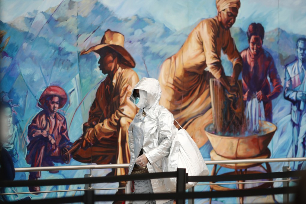 A traveller in protective gear passes a mural on the way to the security checkpoint at Denver International Airport on Wednesday. Photo: AP