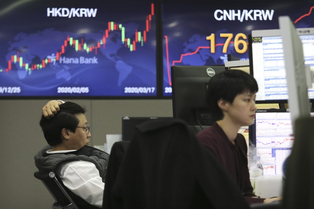 Currency traders watch monitors at the foreign exchange dealing room of KEB Hana Bank in Seoul, on Tuesday. South Korean shares continued to decline on Thursday. Photo: AP Photo