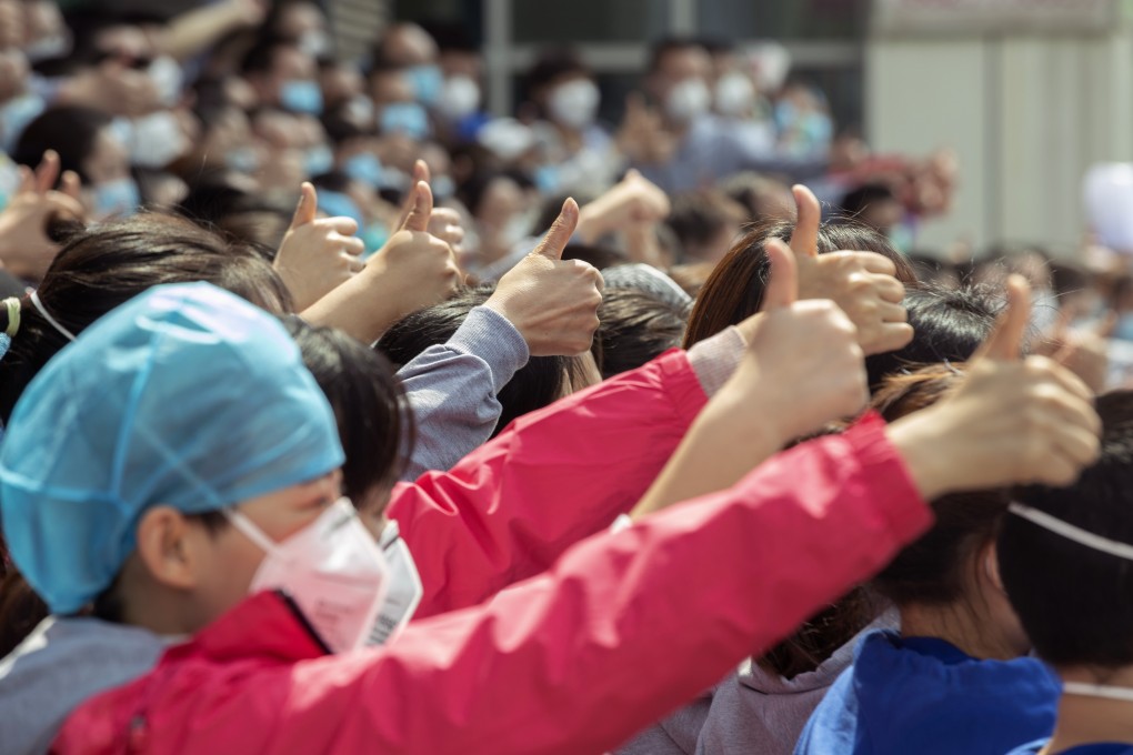 A team of volunteer medical workers give the thumbs-up as they prepare to leave Wuhan where they helped fight the Covid-19 epidemic. Photo: Xinhua