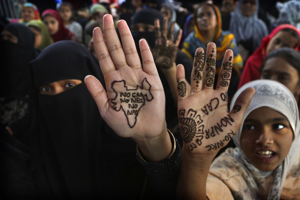Indian women and children display slogans written with henna on their palms during a protest against a new citizenship law in Bangalore, India on March 1. Photo: AP