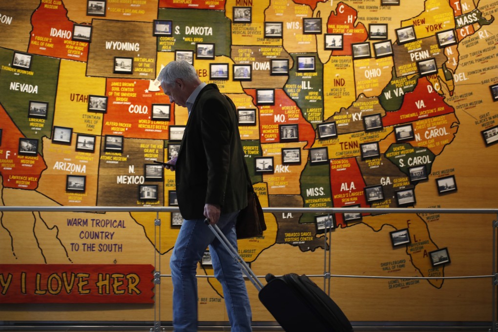 A traveller walks past a map of the United States in Denver International Airport on Wednesday. Photo: AP