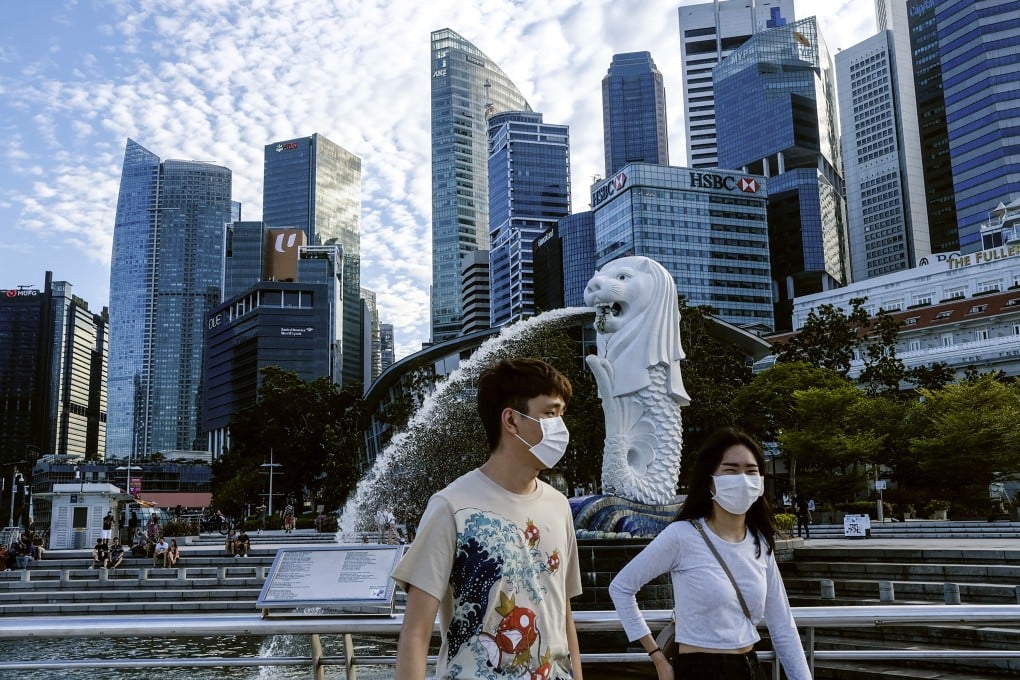 A couple wearing face masks walk past the Merlion statue in Singapore. Many Singaporeans came forward with offers of assistance for commuting Malaysian workers after Malaysia imposed a lockdown on travel due to the coronavirus outbreak. Photo: AP
