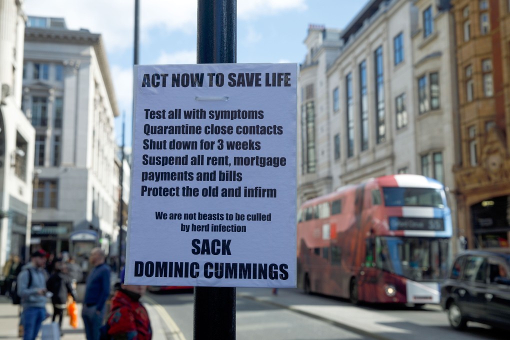 A sign prompting action because of a coronavirus outbreak, and calling for British Prime Minister Boris Johnson’s special adviser Dominic Cummings to be sacked, hangs on a lamp post on Oxford Street in central London on March 16. Retail has become a bellwether of the coronavirus crisis as China begins to recover and Europe goes into free fall. Photo: Bloomberg