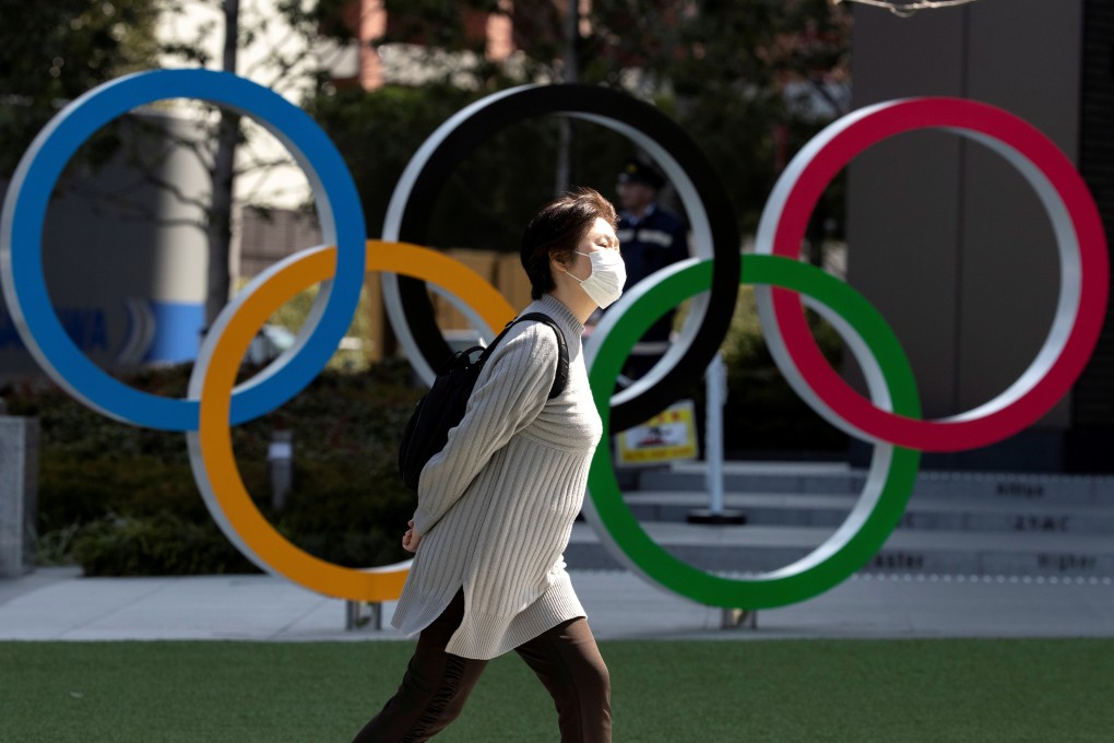 A woman wearing a protective face mask, following an outbreak of the coronavirus disease (Covid-19), walks past the Olympic rings in front of the Japan Olympics Museum in Tokyo. Photo: Reuters