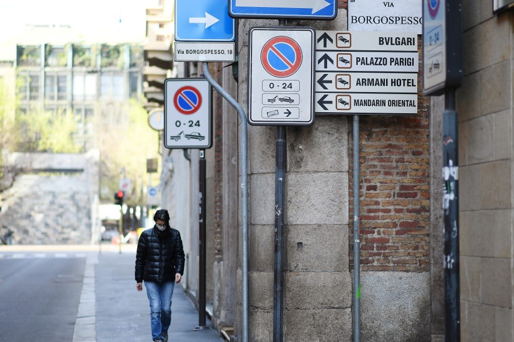 A woman wearing a protective face mask walks along a street in Milan as the spread of coronavirus continues. Photo: REUTERS