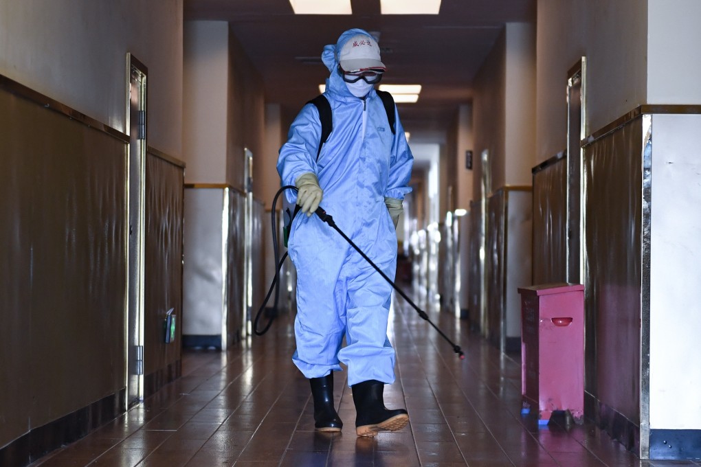 A worker disinfects the corridor of a hotel used for health checks in Shenzhen on Saturday. Authorities are now focused on imported cases. Photo: Xinhua