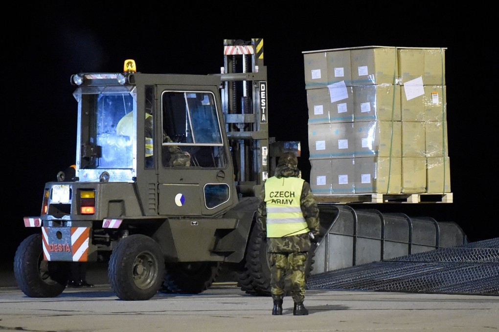 Soldiers unload a plane delivering medical and protective gear from China at an airport in the Czech city of Pardubice on Sunday. Photo: AFP