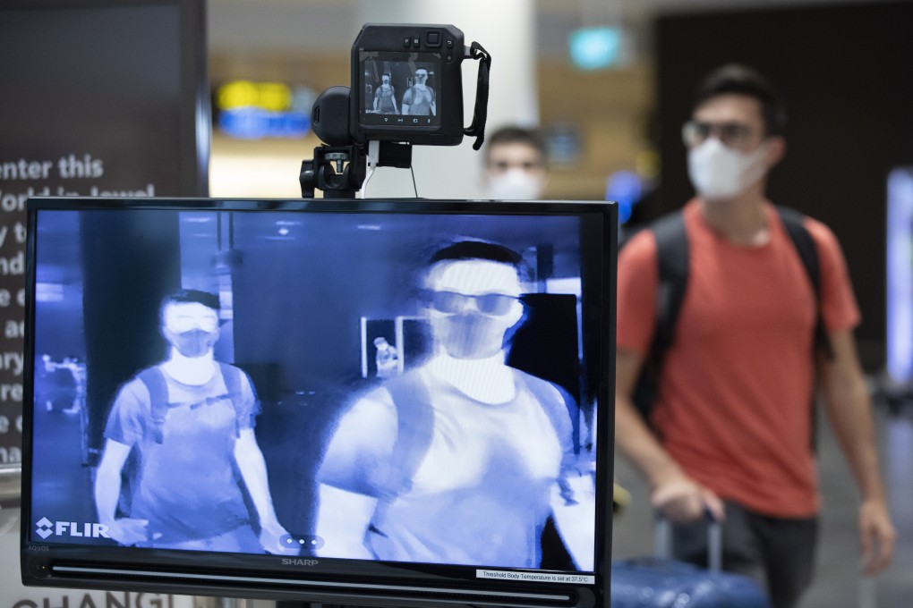 Travellers undergo a temperature check at Singapore’s Changi Airport. Photo: EPA