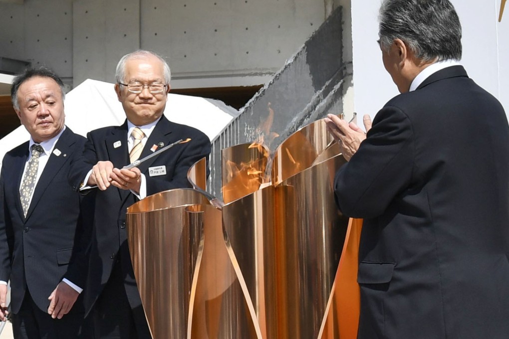 Japanese officials welcome the Olympic flame to Ofunato, Iwate Prefecture, as it tours the country ahead of the Games. Photo: Kyodo