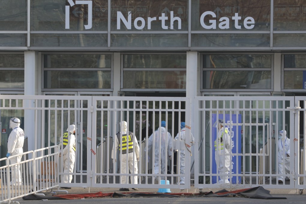 Workers wear protective masks and suits at the New China International Exhibition Centre, which was converted into a transfer centre for inbound passengers, close to Beijing Capital International Airport. Photo: EPA-EFE