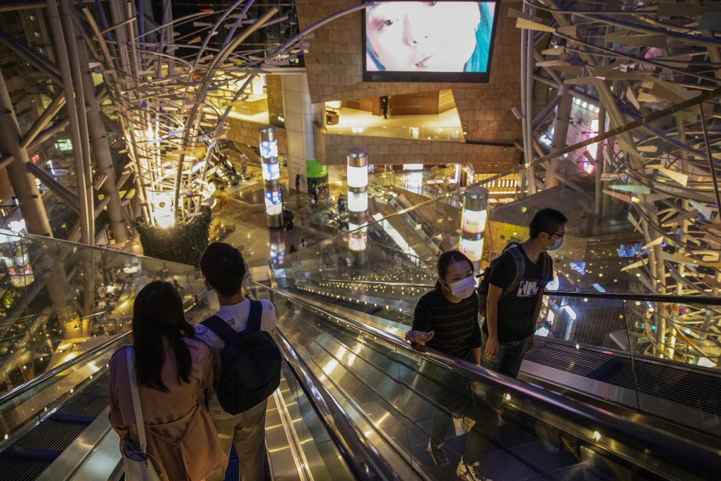 People wear face masks as a precautionary measure against the Covid-19 respiratory disease in an empty shopping centre in Mong Kok. Retail sales have been badly hit because of the outbreak. Photo: Winson Wong