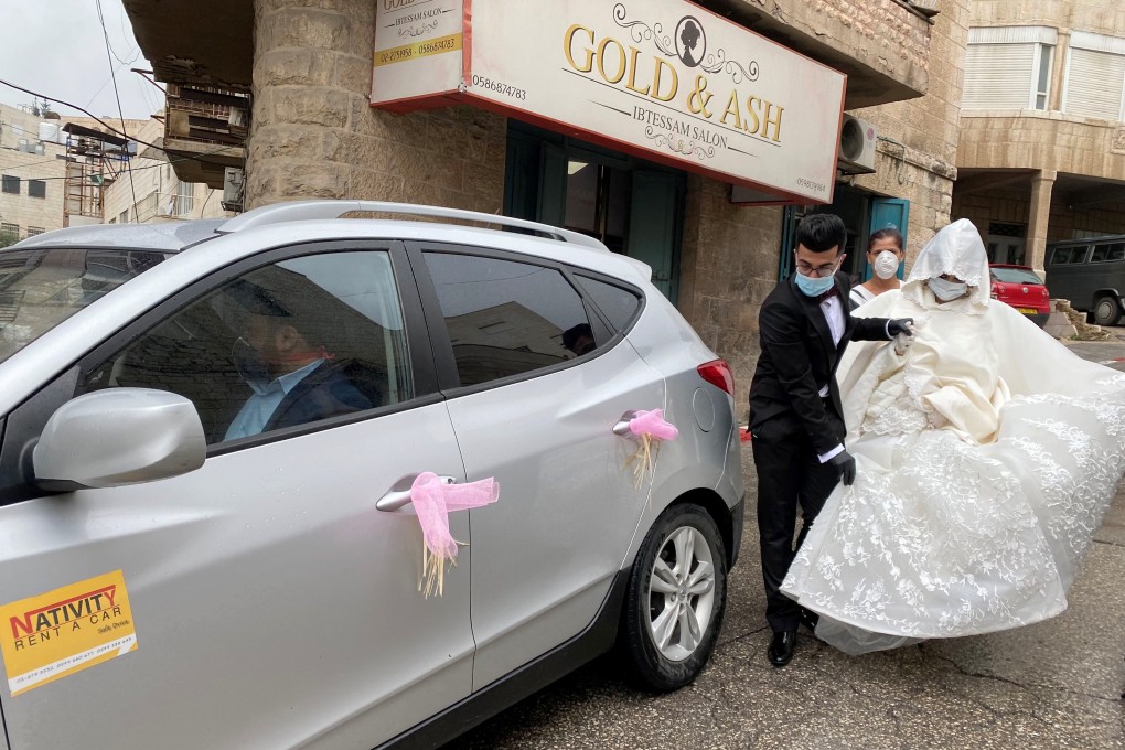 Palestinian bride and groom Baraa Amarneh and Imad Sharaf, wearing masks as a preventive measure against the coronavirus, leave a hairdressing salon on their wedding day in Beit Jala, Hebron, in the Israeli-occupied West Bank. Photo: Reuters