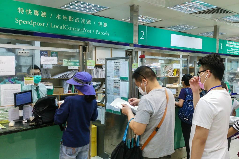 People queue to send express parcels at a post office in Yuen Long. Photo: Brian Wong