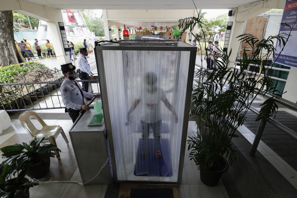 Volunteers and government workers are disinfected inside a cubicle before they enter the local city hall to help prevent the spread of the new coronavirus in Manila, the Philippines. Photo: AP