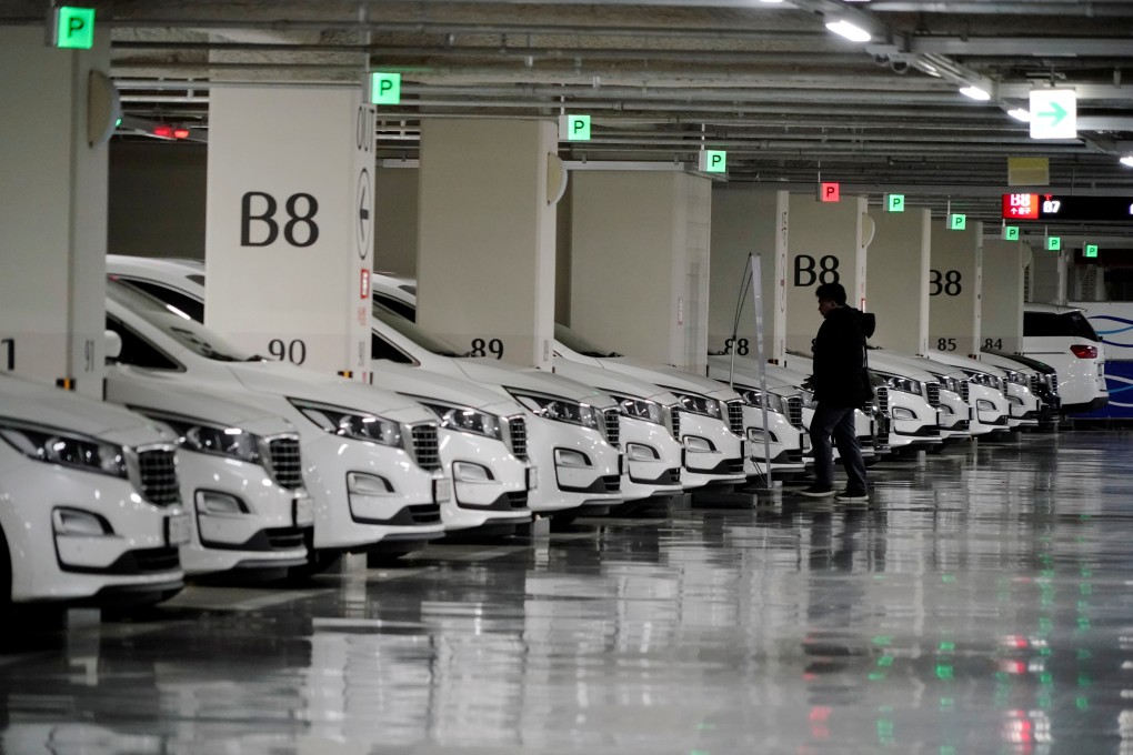 A driver walks past vehicles of ride-hailing service operator Tada at its garage in Seoul on February 17. Photo: Reuters