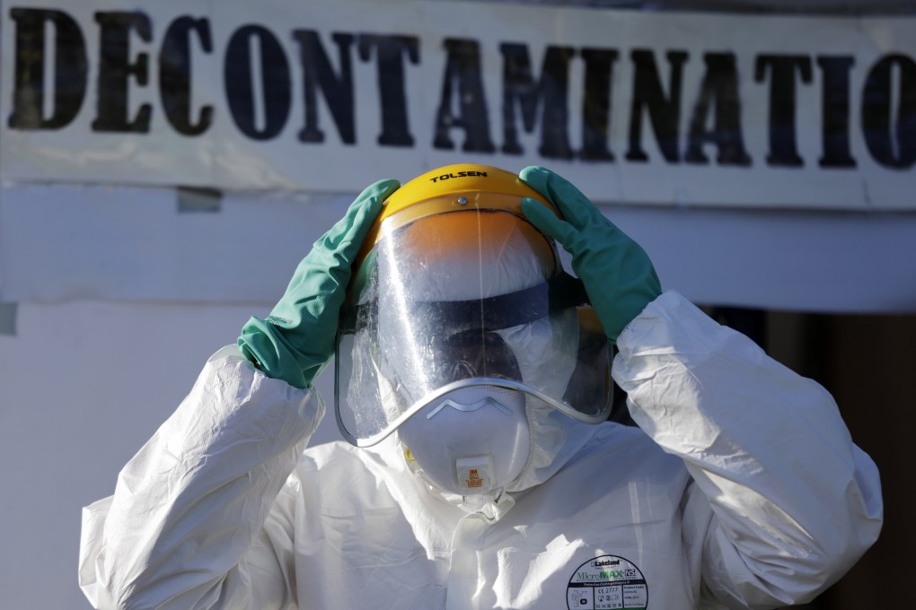 An emergency worker wears protective gear at a coronavirus decontamination booth in the Philippines. The country’s health workers are dealing with a surge in Covid-19 cases and have complained of insufficient protective equipment. Photo: EPA-EFE