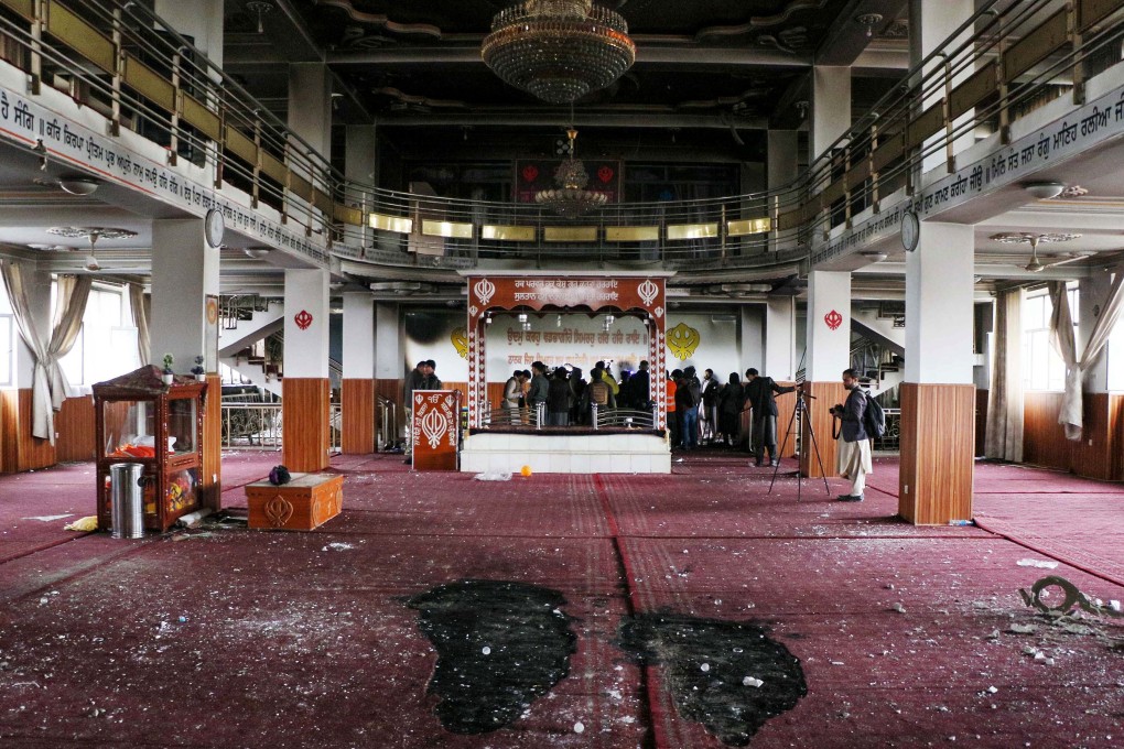 Security personnel inspect a damaged Sikh-Hindu Temple alongside with media representatives following a gun attack in Kabul. Photo: AFP