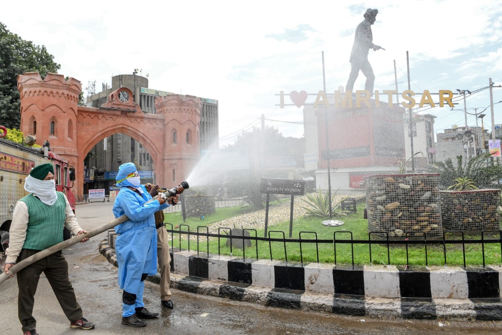 Workers disinfect a statue of Indian Sikh independence activist Shaheed Udham Singh in Amritsar as a precaution against the coronavirus. Photo: AFP