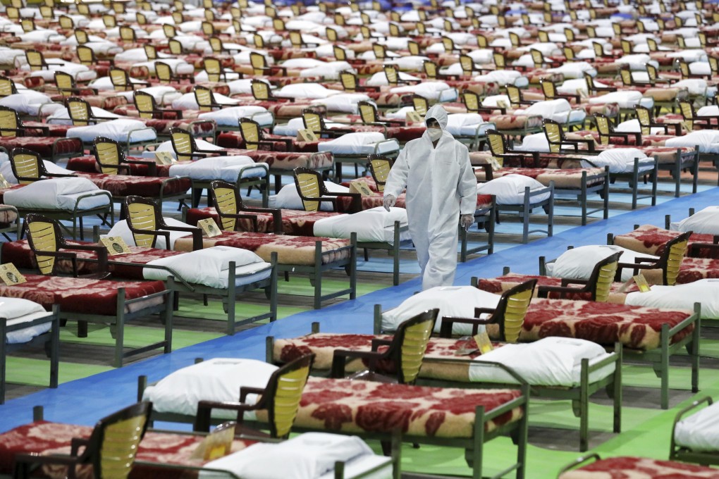 A person in protective clothing walking through a temporary 2,000-bed hospital for COVID-19 coronavirus patients set up by the Iranian army at the international exhibition center in northern Tehran, Iran, this month. Photo: AP