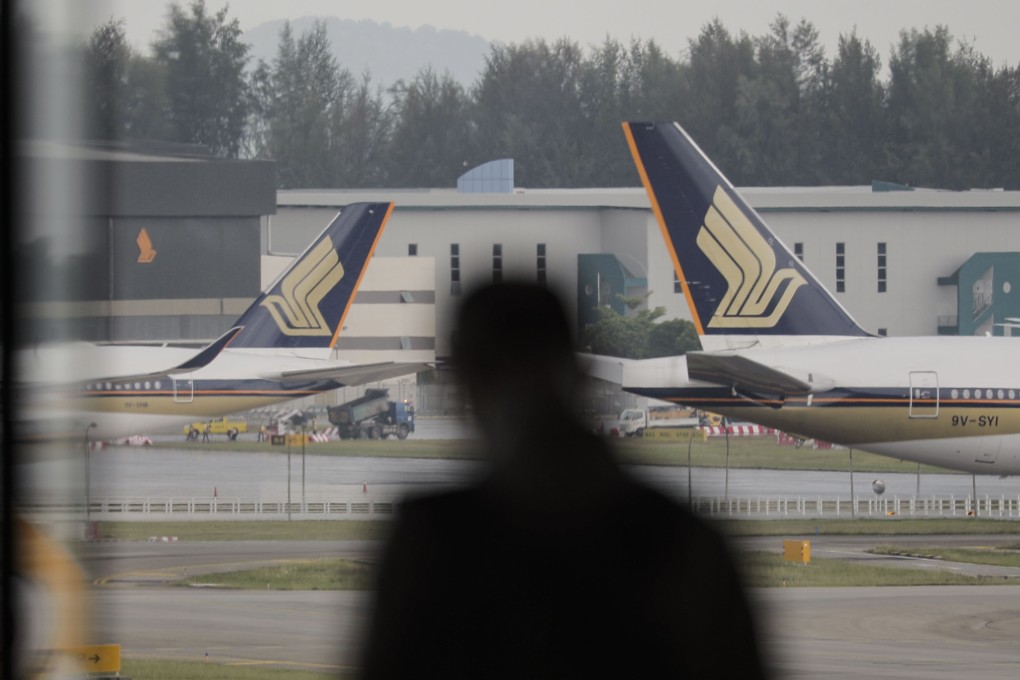 A man looks out at two Singapore Airlines planes at Changi Airport in Singapore on Monday. Photo: EPA-EFE