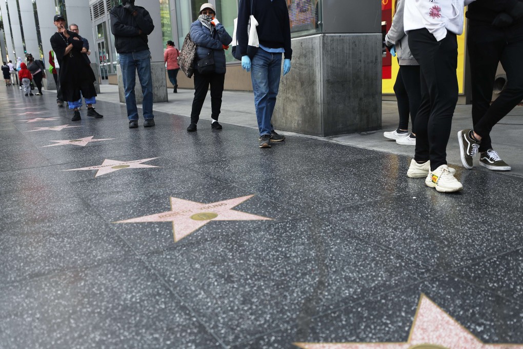 Customers maintain social distancing while standing in line Wednesday to enter a Trader Joe's supermarket along the Hollywood Walk of Fame, as the coronavirus pandemic expands in California. Photo: Getty Images via AFP