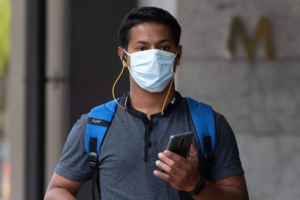 A man wearing a mask walks through a deserted Wellington CBD on March 26, 2020. Photo: AFP